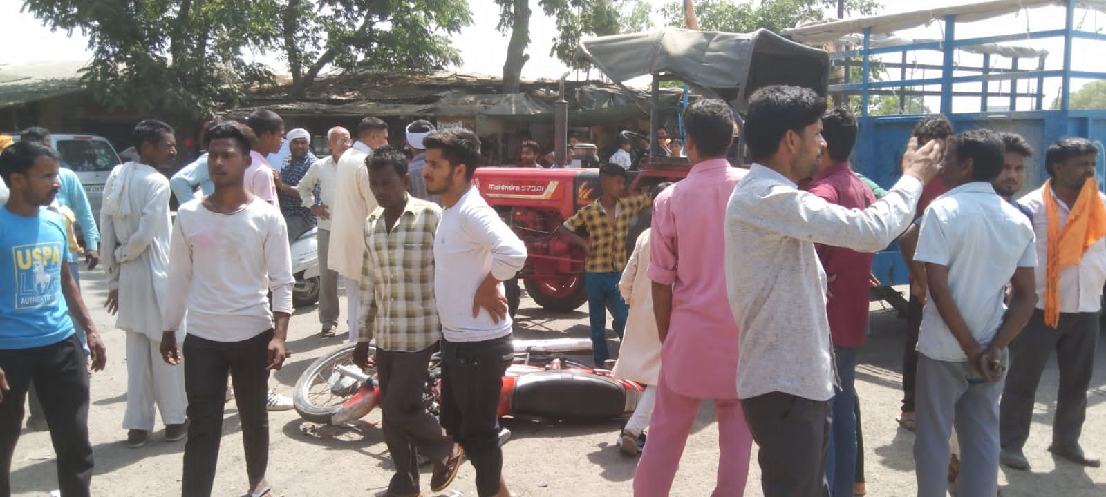 मौके पर पड़ी घायल की बाइक और जमा भीड़ मौके पर पड़ी घायल की बाइक और जमा भीड़