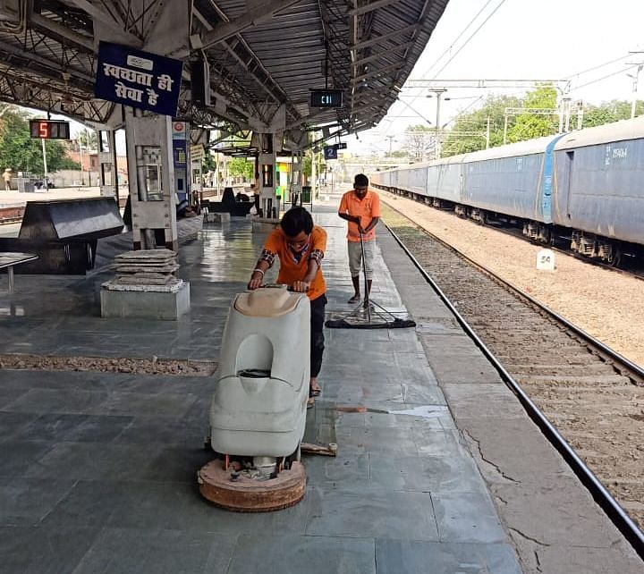 रेलवे स्टेशन पर फ्लोर क्लीनिंग मशीन से परिसर की सफाई करते कर्मचारी। संवाद