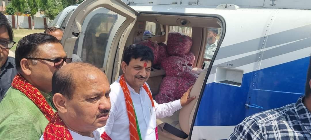 पुष्प वर्षा के लिए हेलीकॉप्टर से रवाना होते राज्यमंत्री कपिलदेव ।