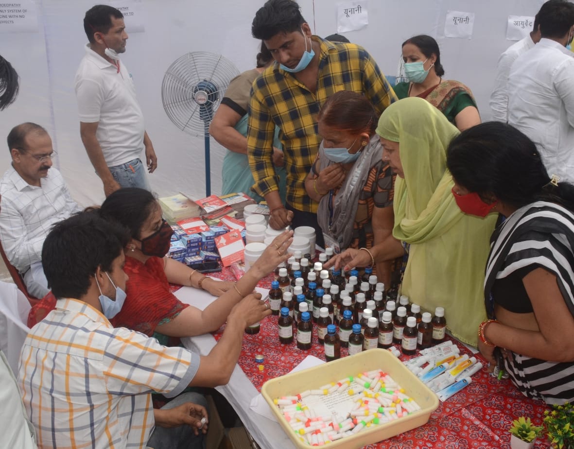 बागपत सीएचसी में आयोजित स्वास्थ्य मेले में दवाई लेते लोग