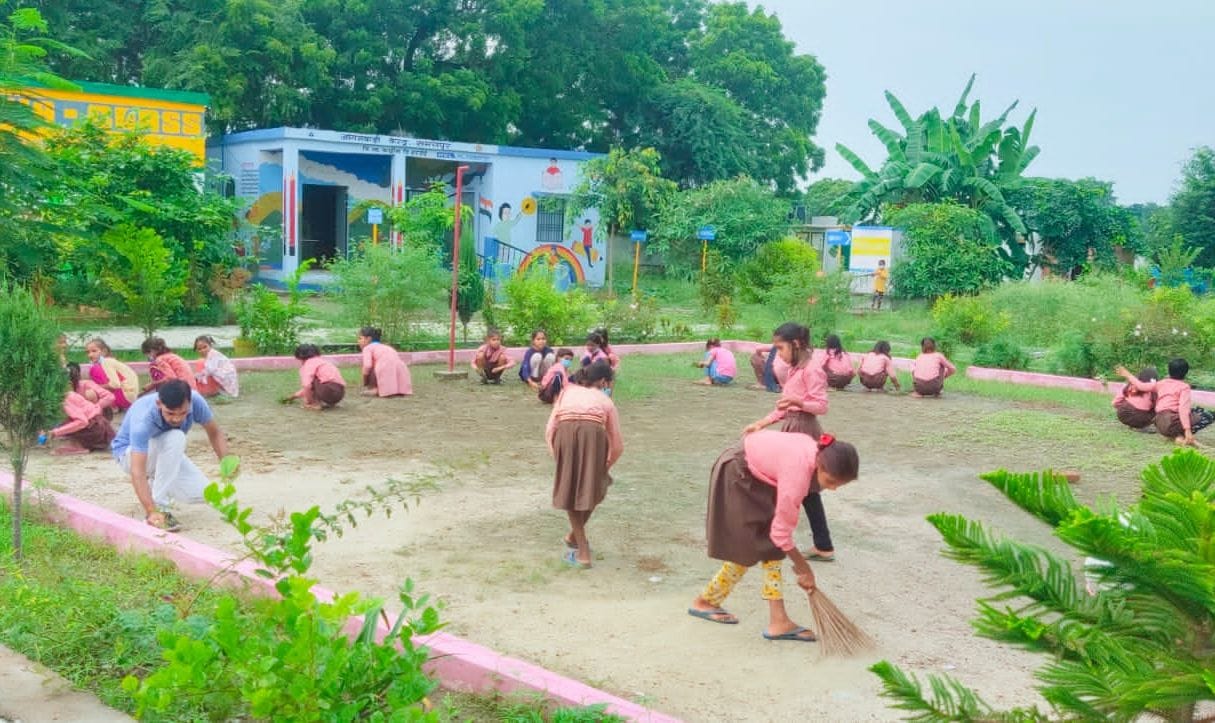फोटो-25-स्कूल ग्राउण्ड की सफाई करतीं छात्राएं