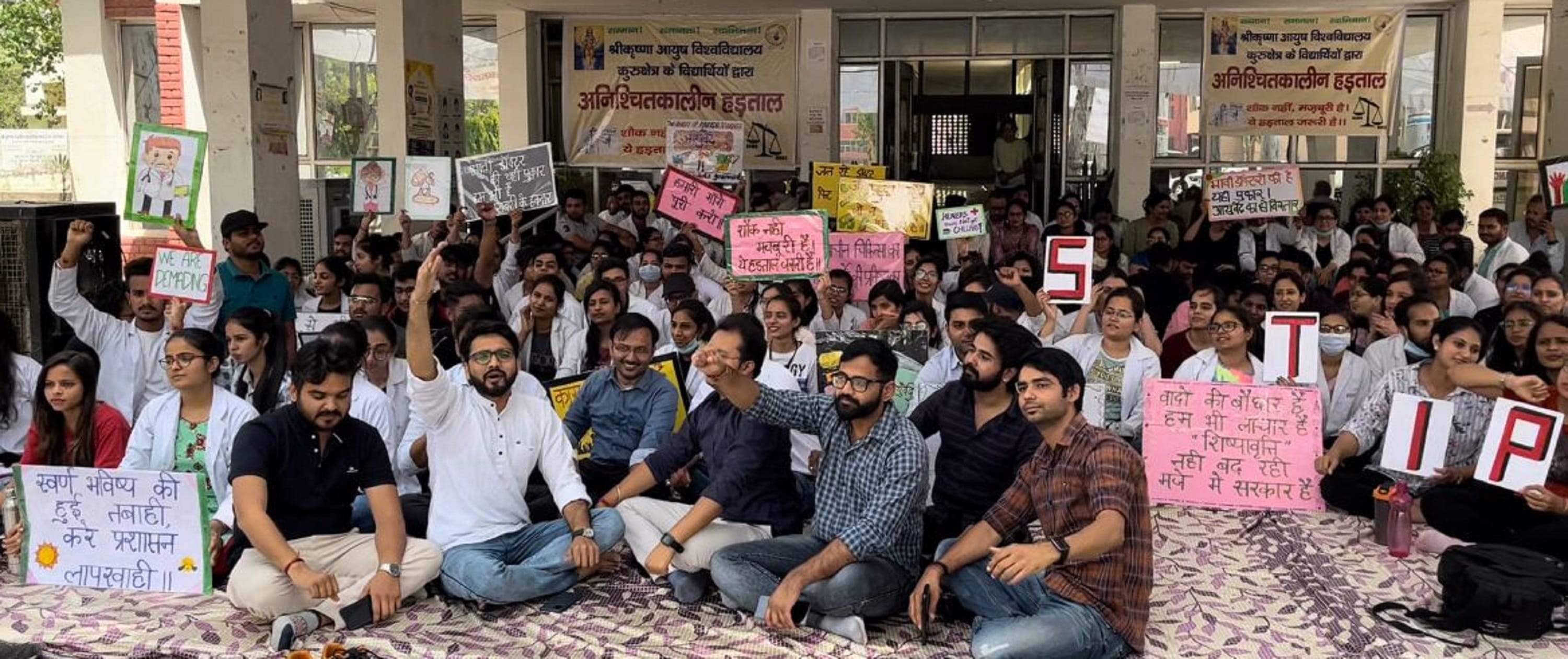 आयुर्वेदिक कॉलेज के बाहर आयुष विश्वविद्यालय प्रशासन के खिलाफ नारेबाजी करतें विद्यार्थी।   संवा?