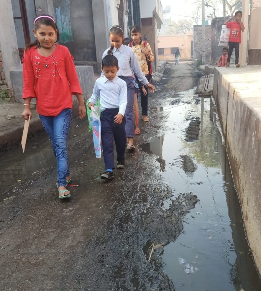 सिनौली गांव में पानी व कीचड़ से भरी गली से गुजरते बच्चे। सिनौली गांव में पानी व कीचड़ से भरी गली से गुजरते बच्चे।