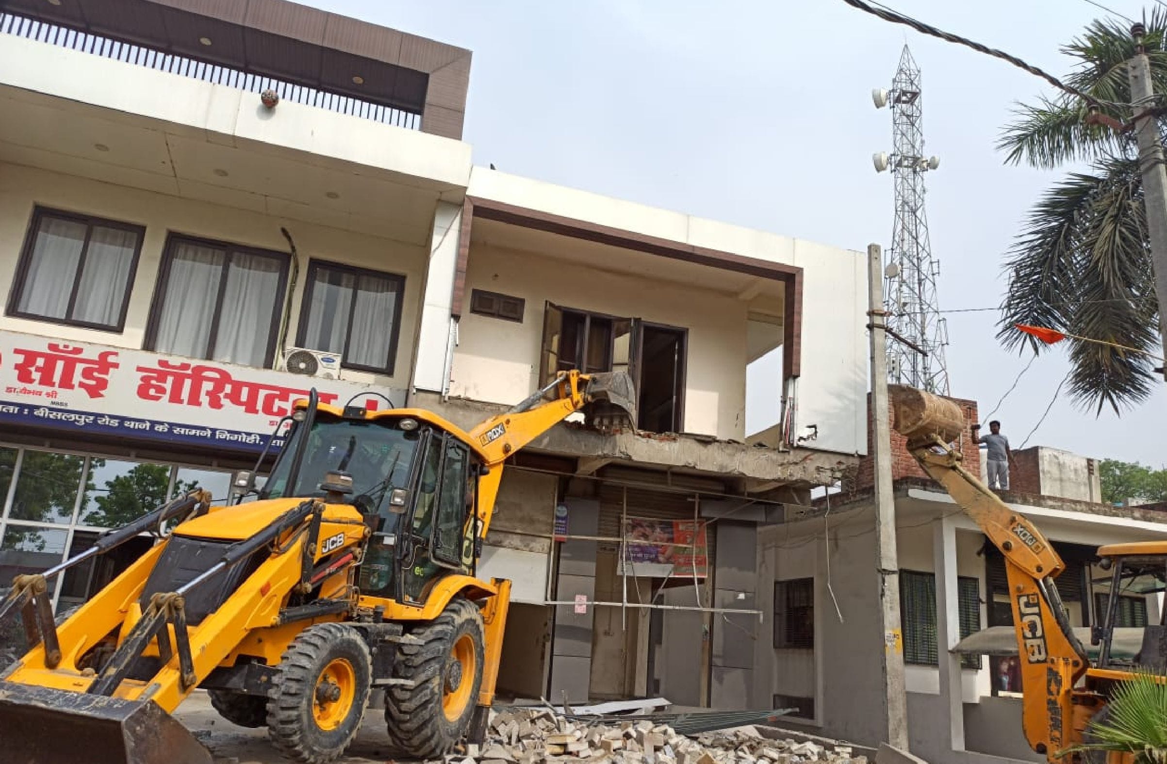 शाहजहांपुर। निगोही में थाने के सामने अवैध निर्माण को तोड़ती जेसीबी। संवाद