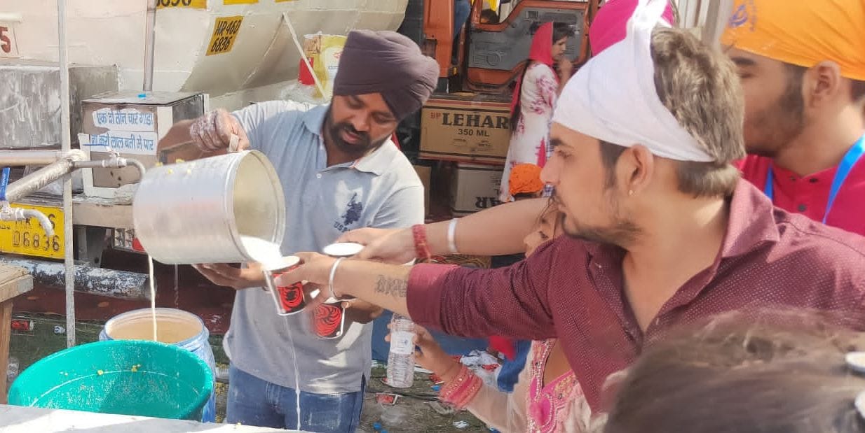 पानीपत। टेंकर से लस्सी को बालटी में निकालकर संगत को देते हुए।