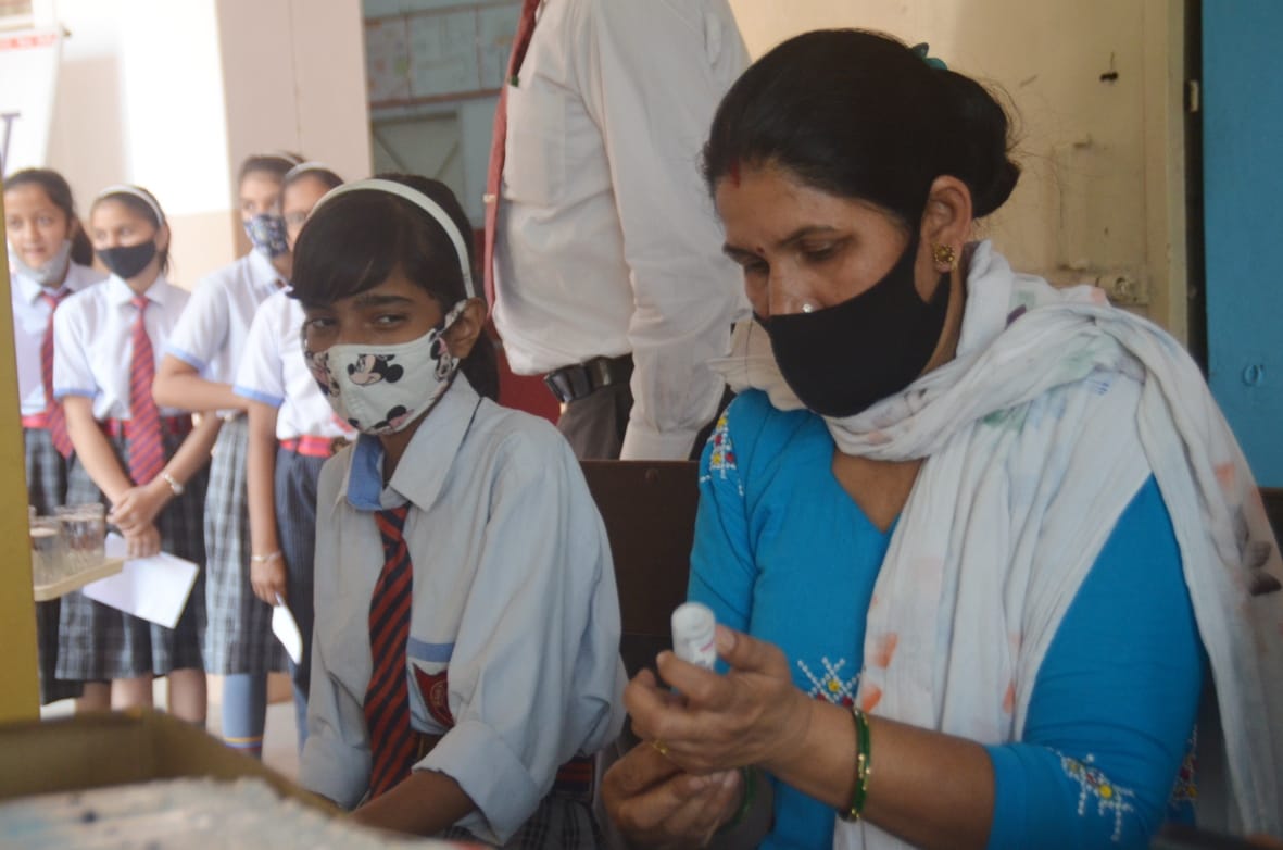 बागपत के सेंट एंजेल्स पब्लिक स्कूल में वैक्सीन की ओर देखती छात्रा बागपत के सेंट एंजेल्स पब्लिक स्कूल में वैक्सीन की ओर देखती छात्रा