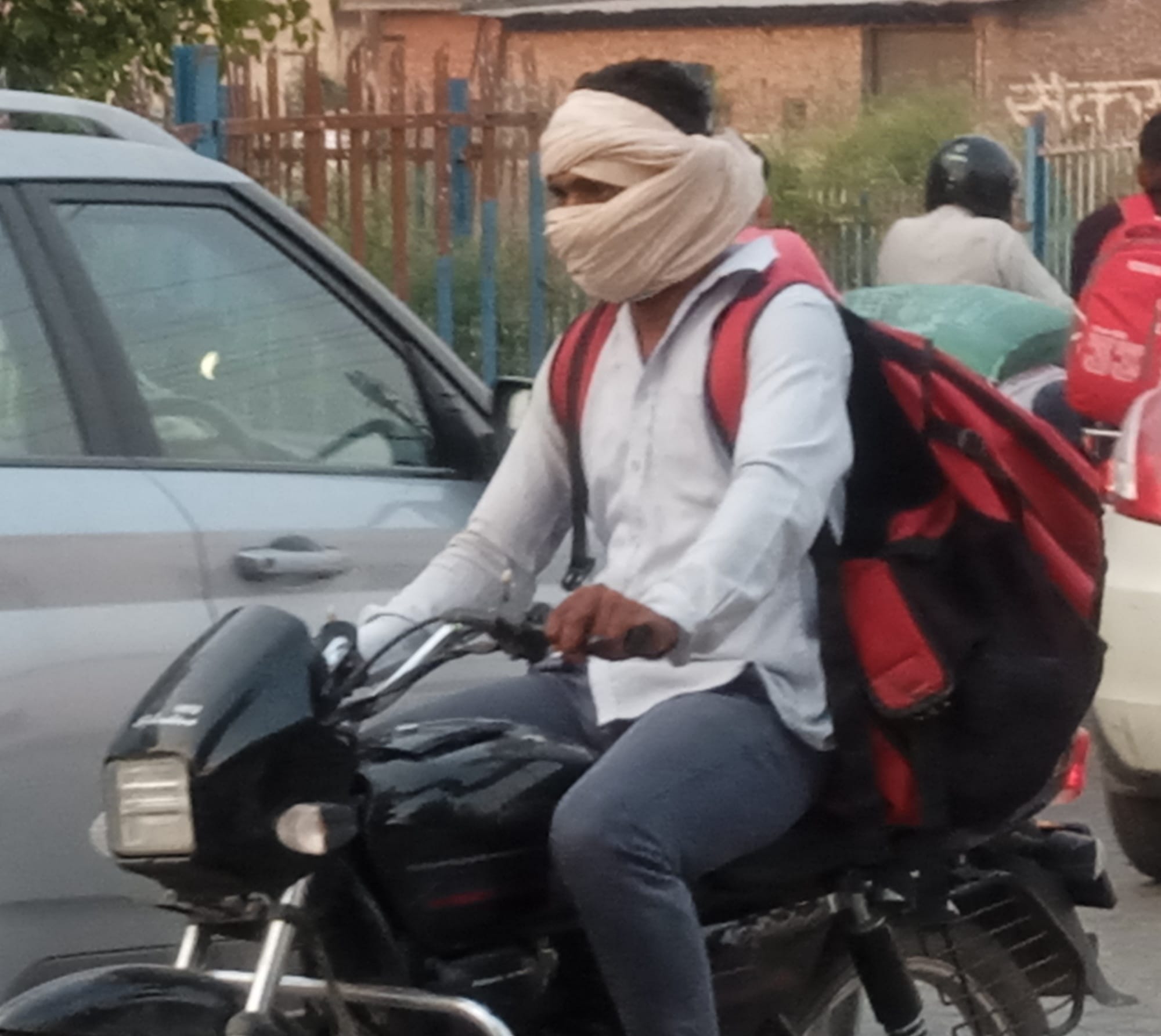 शामली गर्मी में कपड़ा लपेट कर बाइक पर जाता युवक।