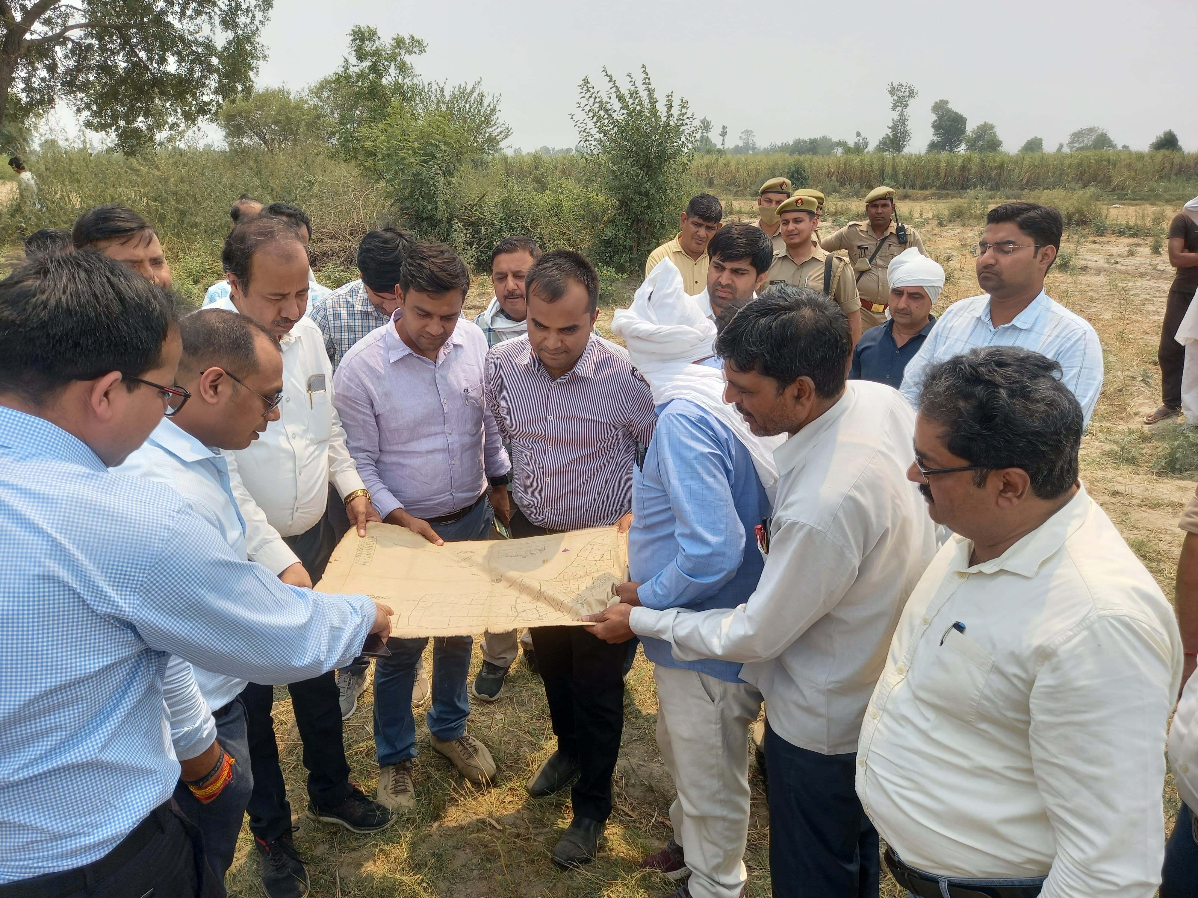 खेड़ा इस्लामपुर के यमुना खादर में नक्शे को देखते डीएम, एडीएम, लखनऊ सर्वे टीम व अन्य अधिकारी