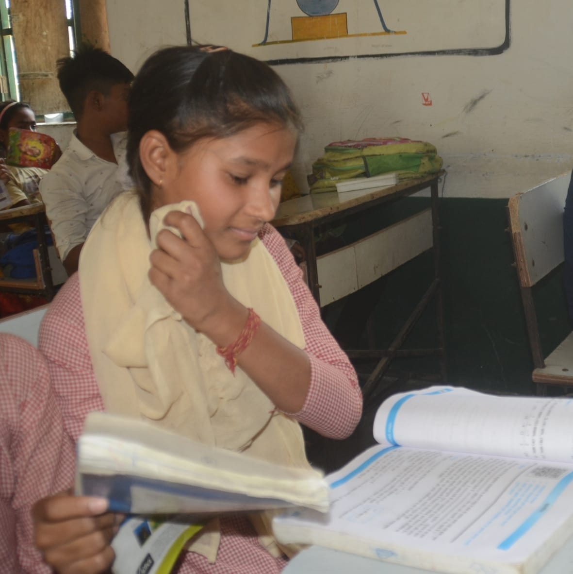 पूर्व माध्यमिक विद्यालय बली में गर्मी के कारण चेहरे से पसीना पौंछती छात्रा