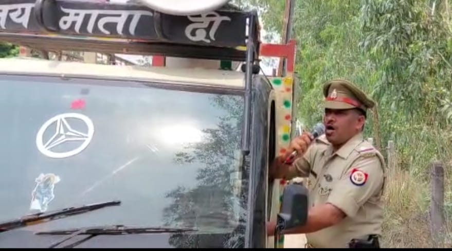 शेरपुर पेलो में हाजी इकबाल की बेनामी संपत्ति को लेकर एनाउंसमेंट करता पुलिसकर्मी