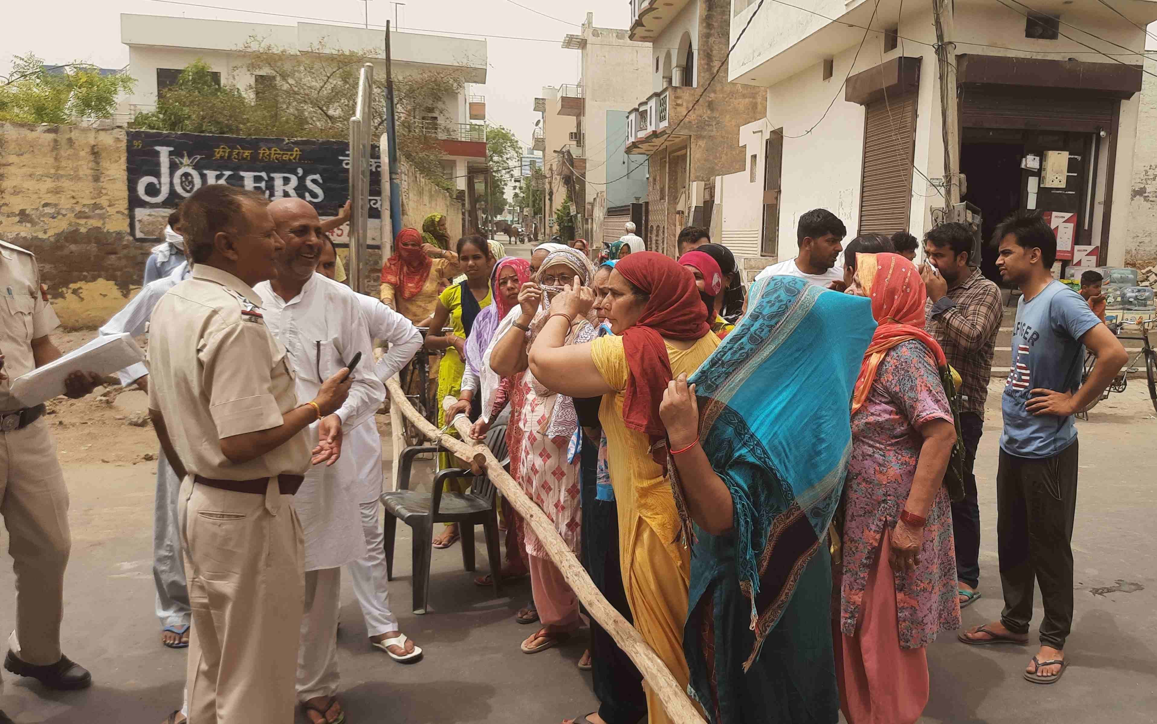 सूरी पेट्रोल पंप वाली गली में सड़क जाम किए जाने के बाद महिलाओं को समझाते पुलिस कर्मी। संवाद