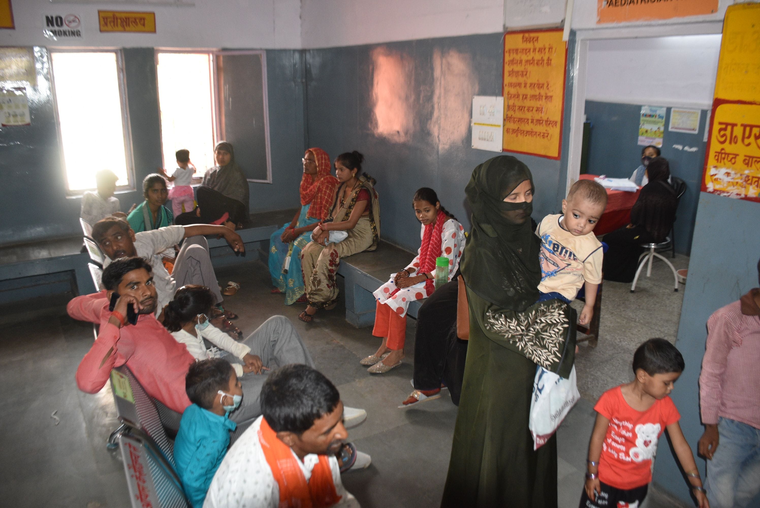 बाल चिकित्सक के कक्ष के बाहर बच्चों के साथ बैठी महिलाएं। संवाद बाल चिकित्सक के कक्ष के बाहर बच्चों के साथ बैठी महिलाएं। संवाद