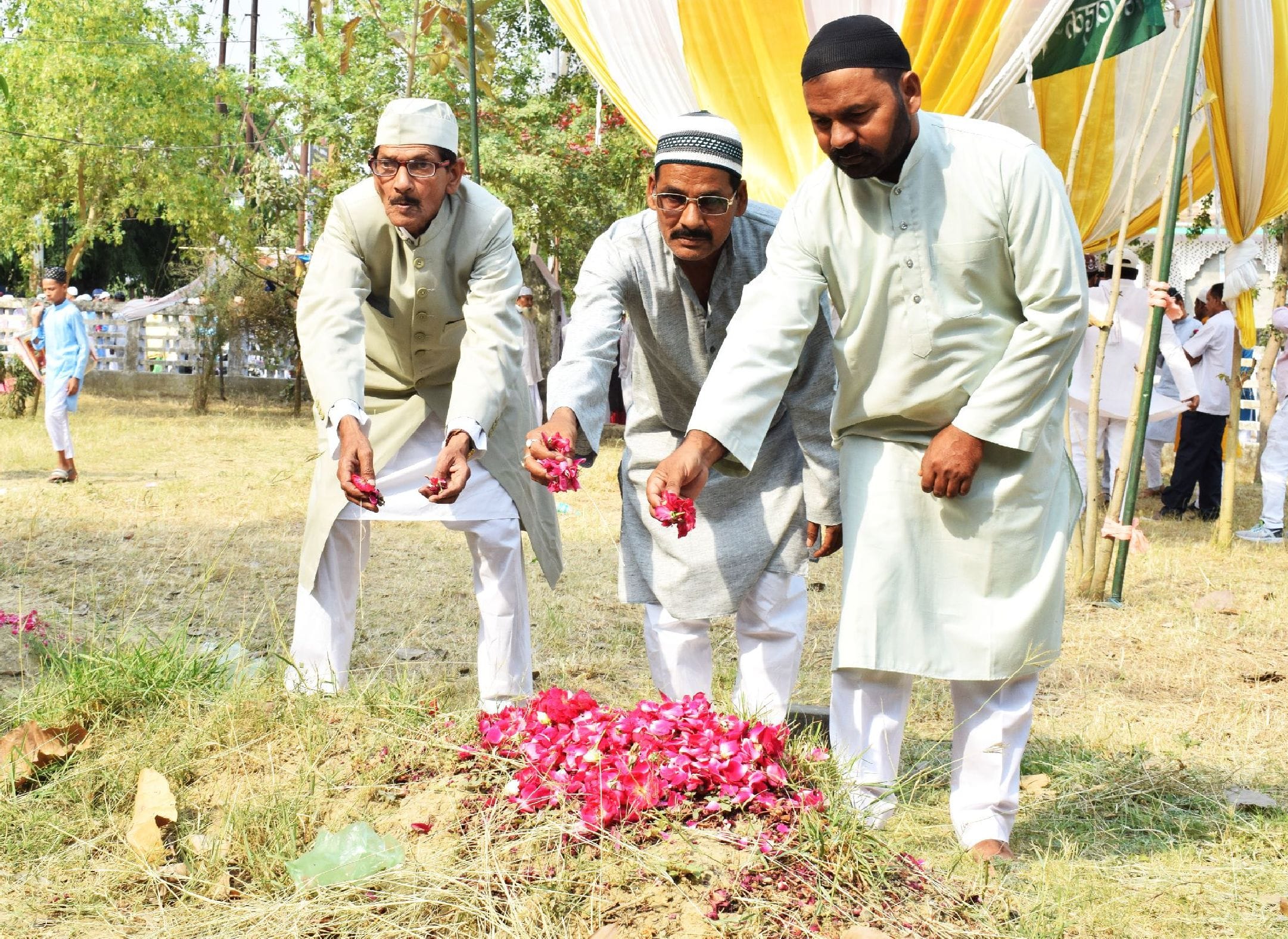 ईद की नमाज के बाद अपने पूर्वज की क्रब पर पुघ्पं चढ़ाते लोग। संवाद