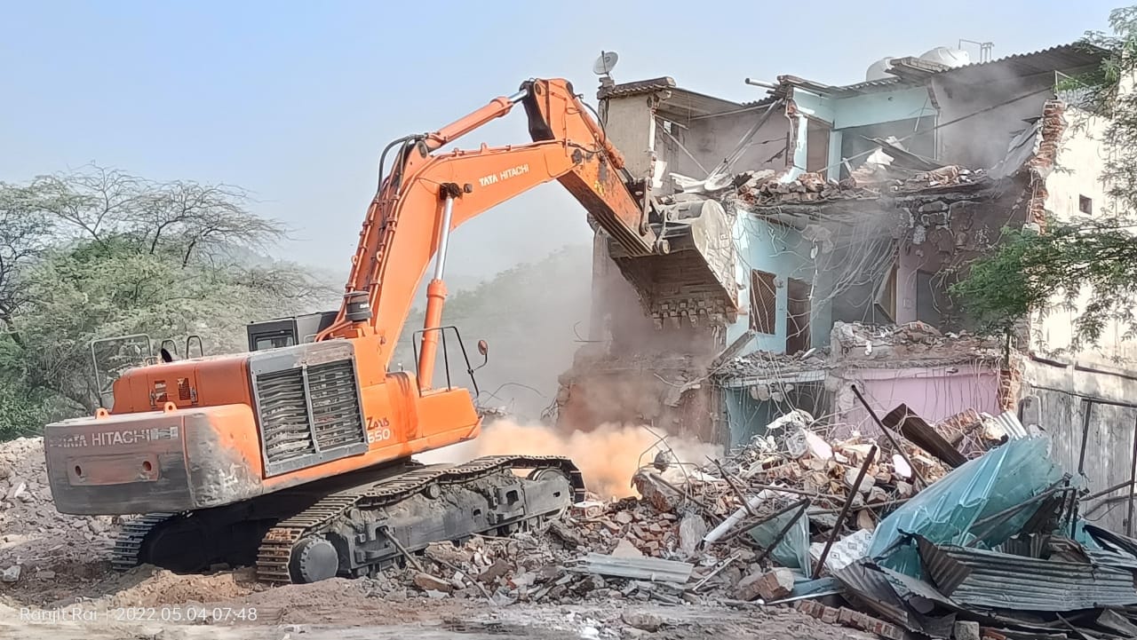 सोनभद्र के शक्तिनगर में पूर्व जिला पंचायत सदस्य के होटल को तोड़ती पोकलेन मशीन।