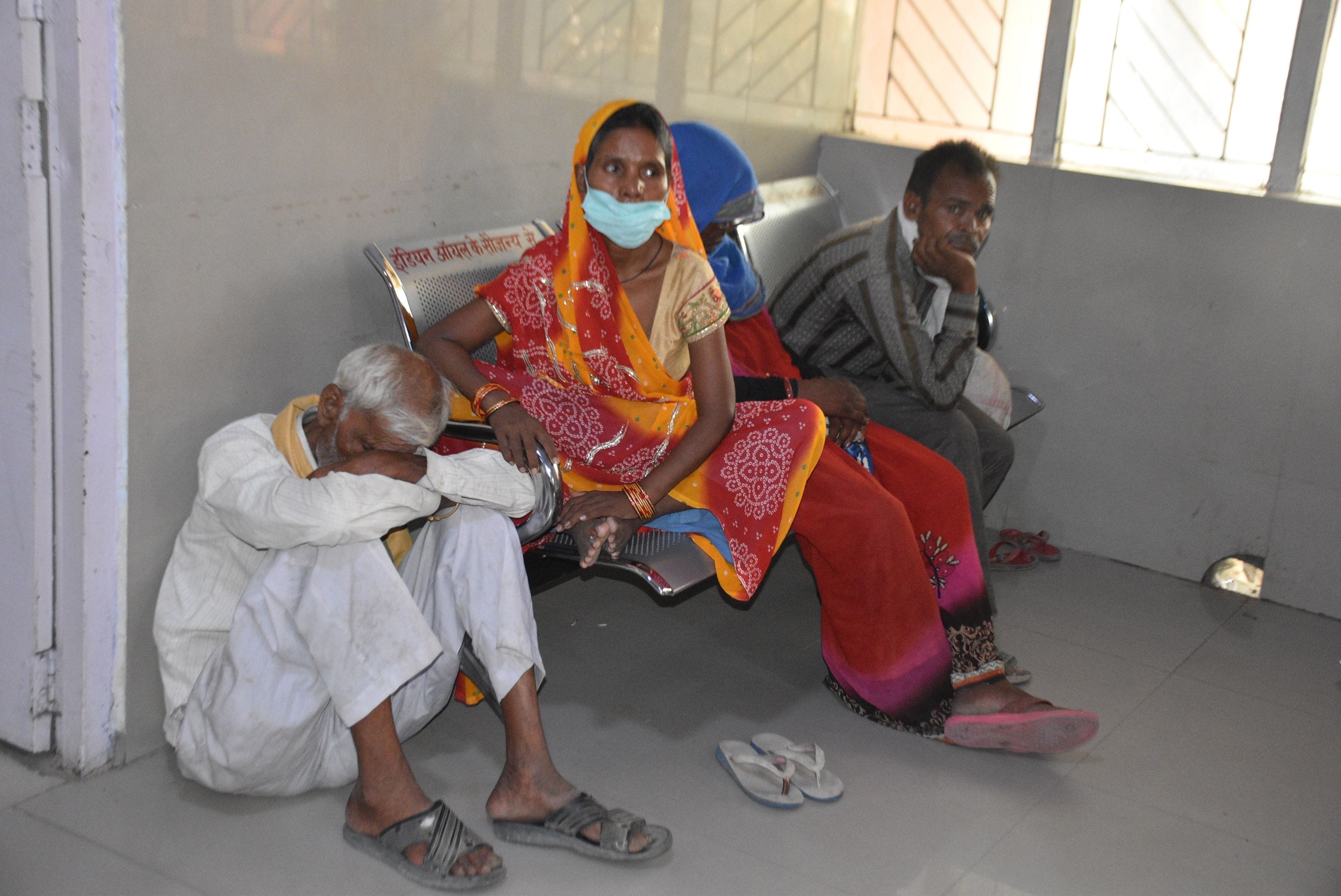 (संशोधित फोटो) जिला अस्पताल में दो घंटे से डॉक्टर के इंतजार में जमीन पर बैठे बुजुर्ग राम स्वरूप व क