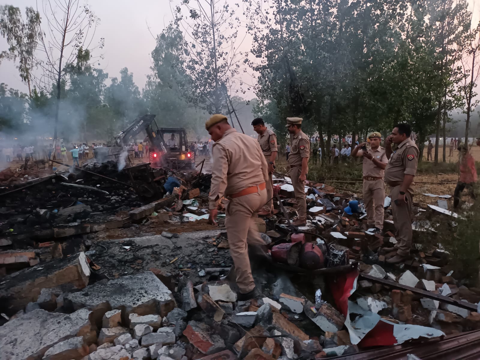विस्फोट के बाद मलबा हटाती जेसीबी और पुलिस विस्फोट के बाद मलबा हटाती जेसीबी और पुलिस