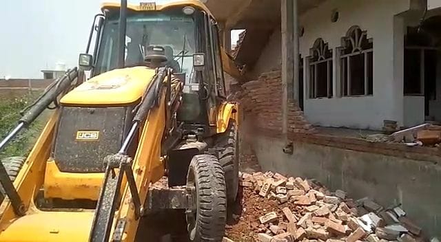 सरकारी जमीन पर बने मकान का एक हिस्सा तोड़ती जेसीबी। संवाद सरकारी जमीन पर बने मकान का एक हिस्सा तोड़ती जेसीबी। संवाद