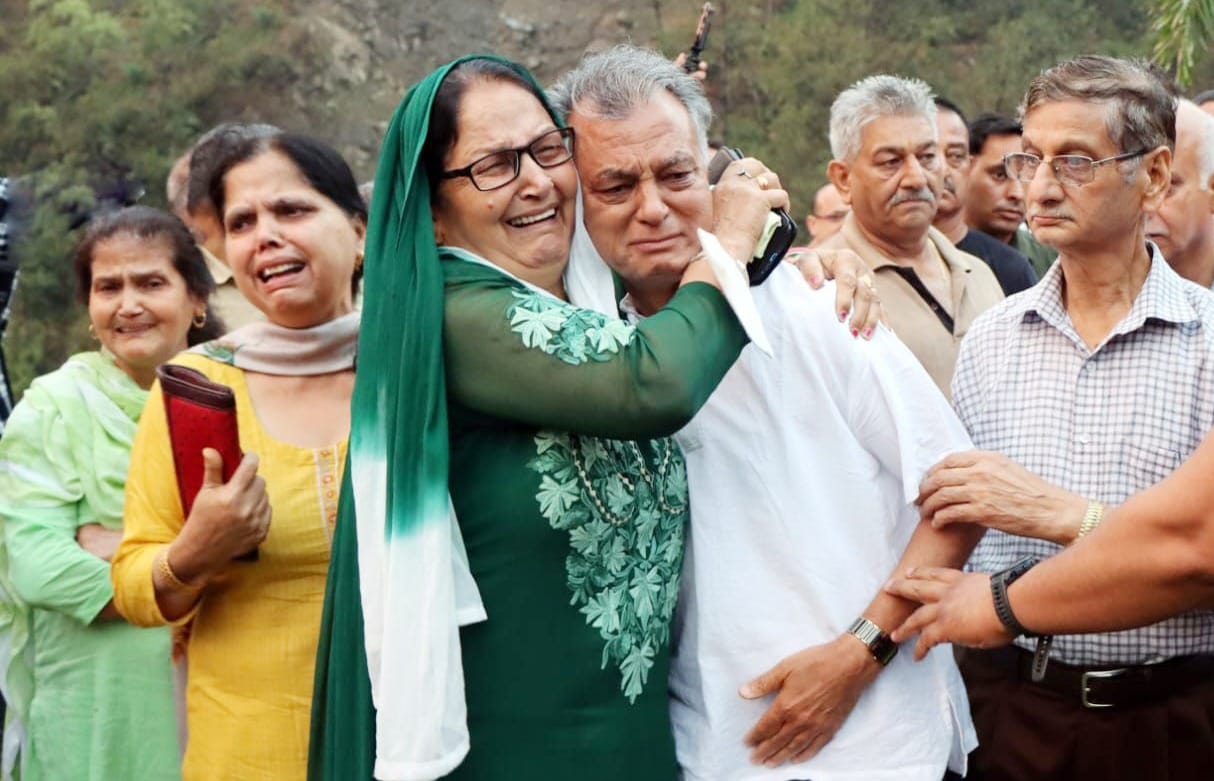 दिवंगत पंडित सुख राम का शव बाड़ी गुमाणु स्थित घर पहुंचने पर बेटे अनिल शर्मा को रोते हुए गले लगा कर 