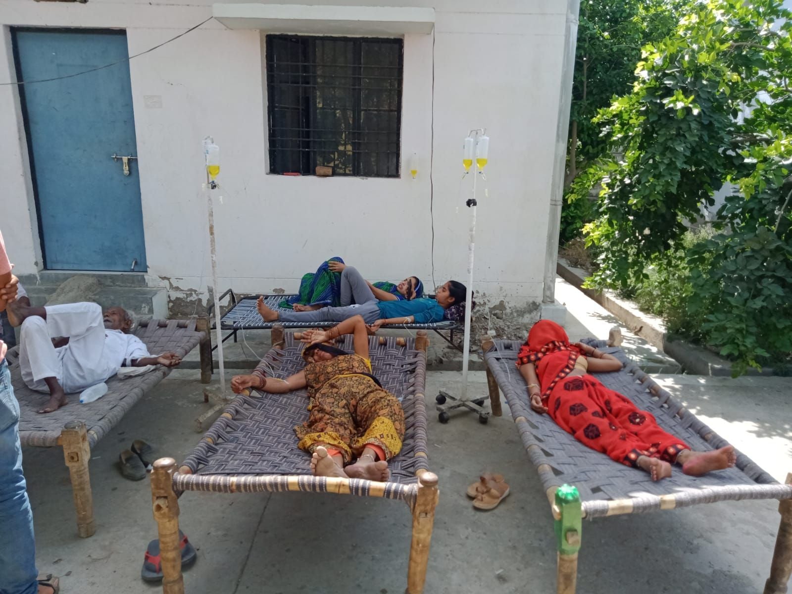 हनुमंतपुरा सीएचसी के बाहर खटिया पर बोतल लगवाए मरीज। संवाद हनुमंतपुरा सीएचसी के बाहर खटिया पर बोतल लगवाए मरीज। संवाद