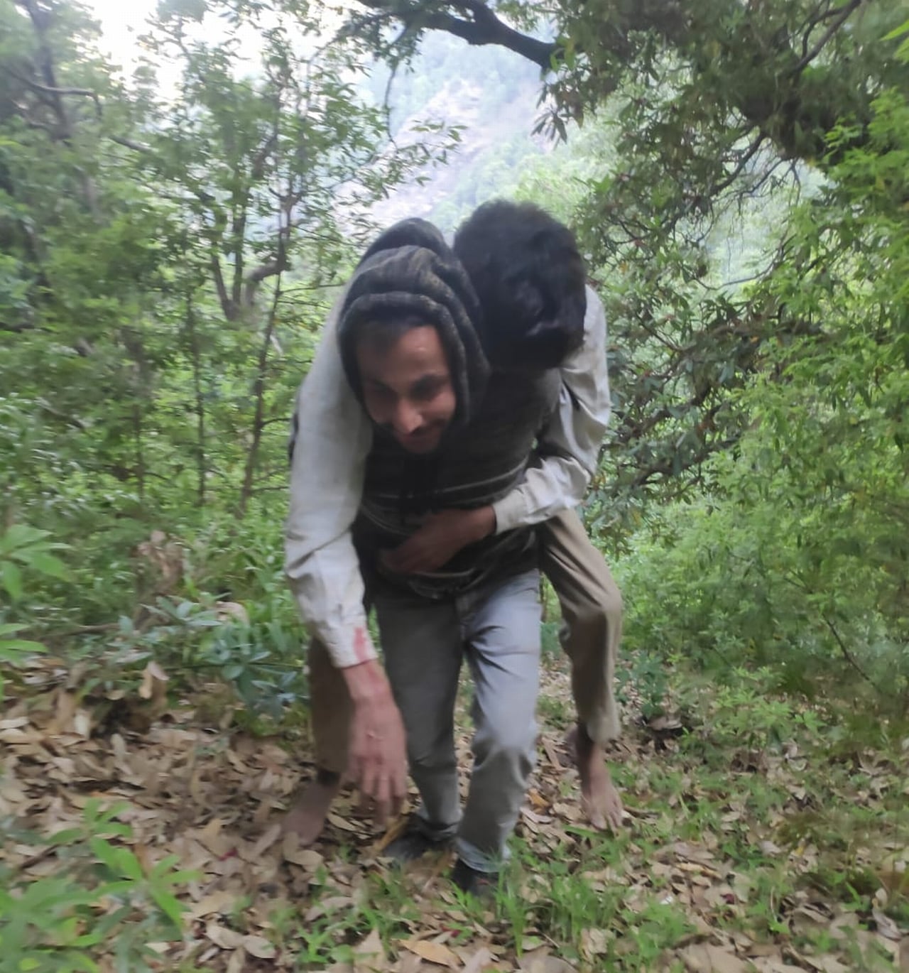 हरिपुरधार-संगड़ाह मार्ग पर हुई सड़क दुर्घटना के बाद घायल को पीठ पर उठाकर सड़क तक पहुंचाता एक ग्रा