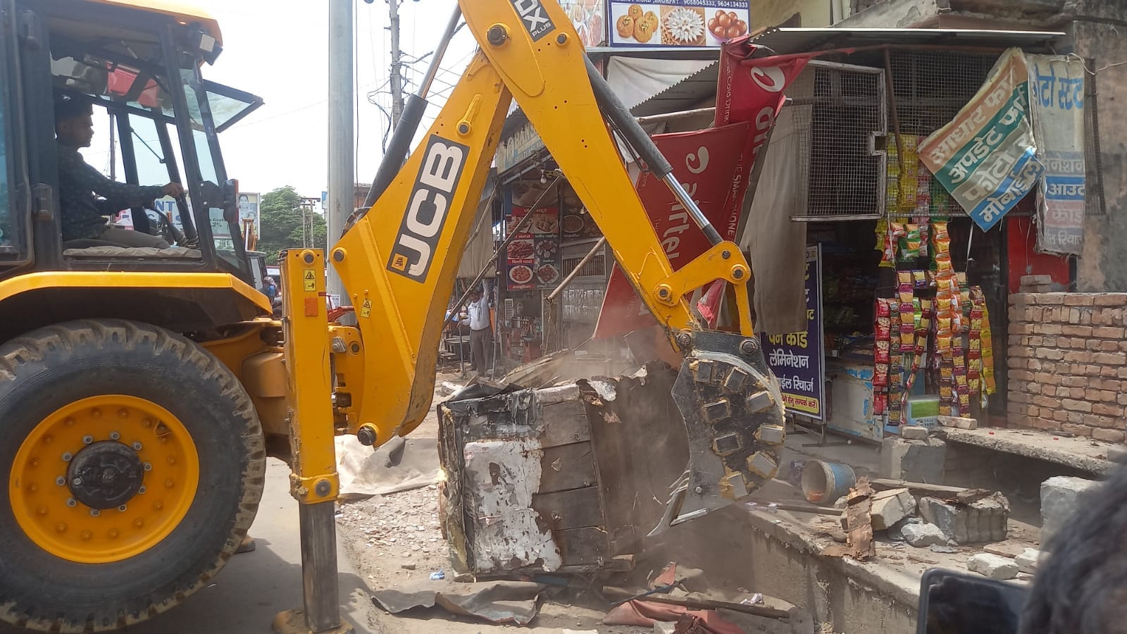 बागपत-मेरठ रोड पर अतिक्रमण हटाती जेसीबी मशीन