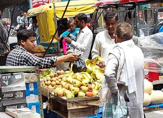 बेहट में ग्राहक को पॉलीथिन में फल डालकर देता विक्रेता बेहट में ग्राहक को पॉलीथिन में फल डालकर देता विक्रेता