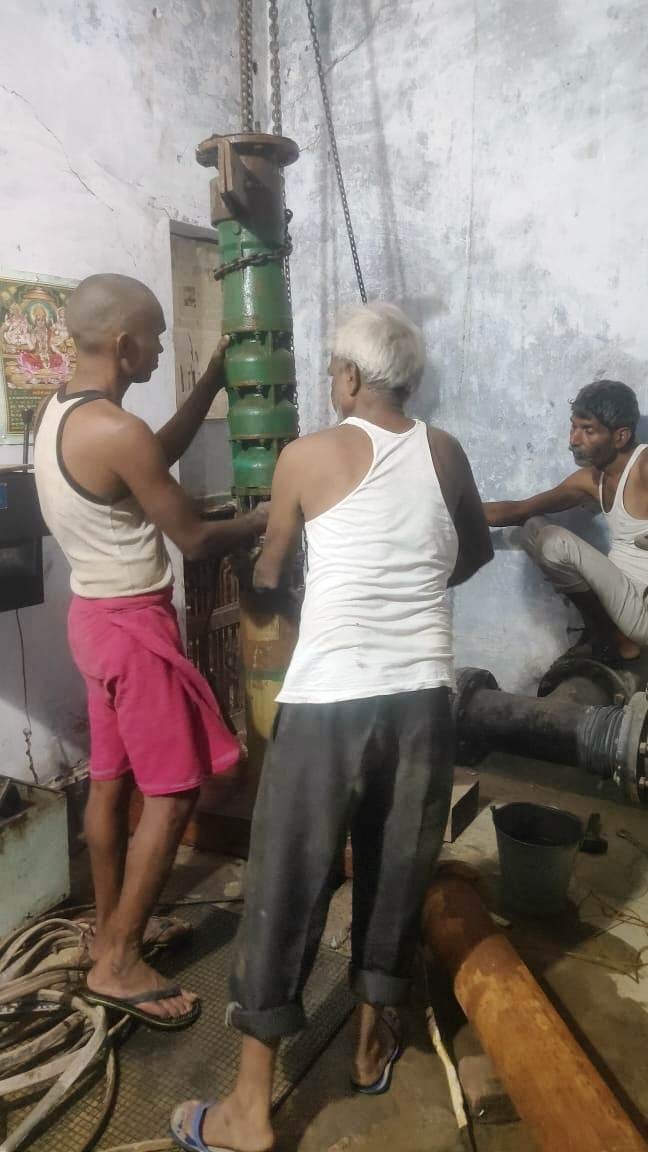 पानी की मोटर निकालते मिस्त्री। संवाद