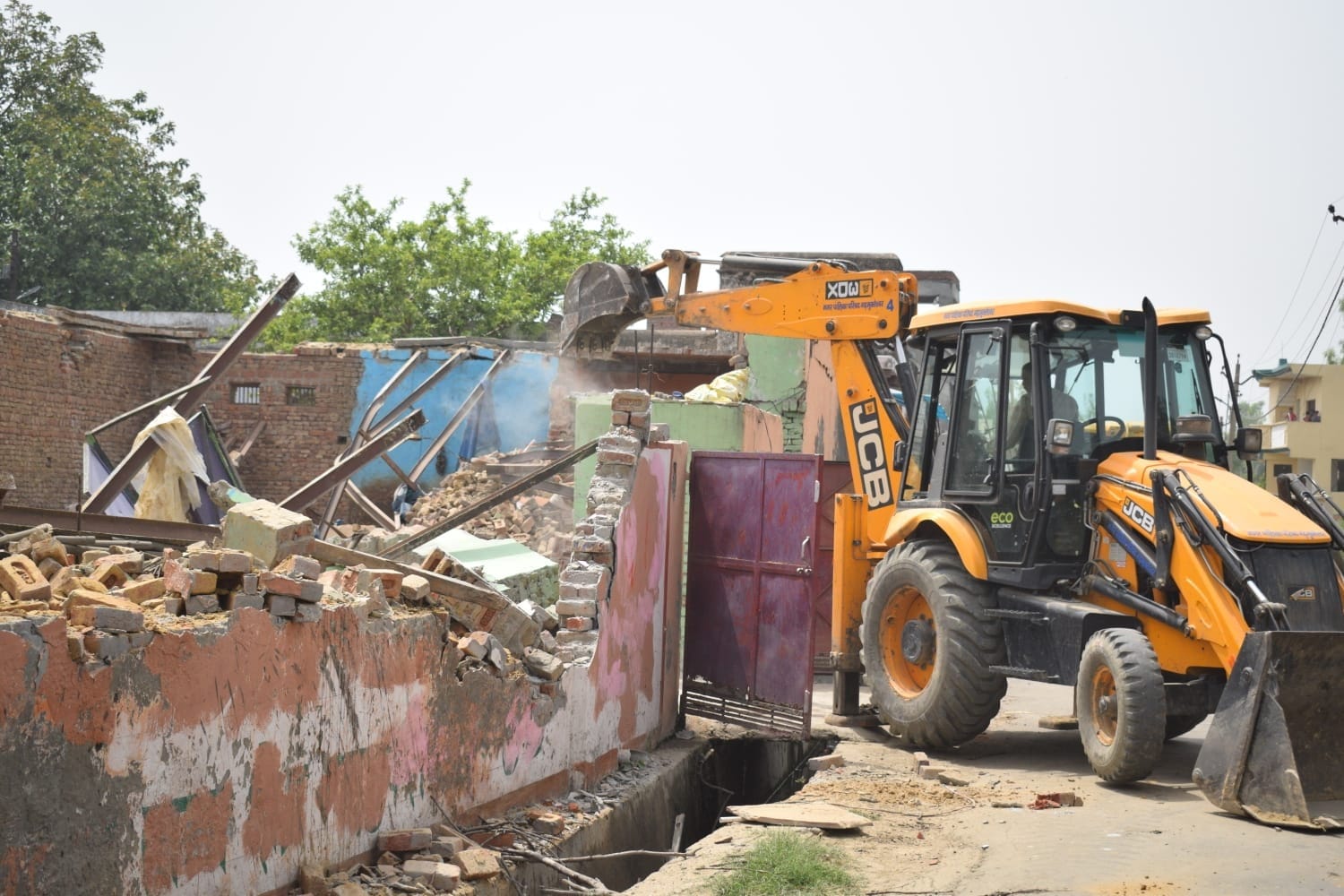 गढ़ में नक्का कुआं मंदिर के पास भवन ध्वस्त करता बुलडोजर। गढ़ में नक्का कुआं मंदिर के पास भवन ध्वस्त करता बुलडोजर।