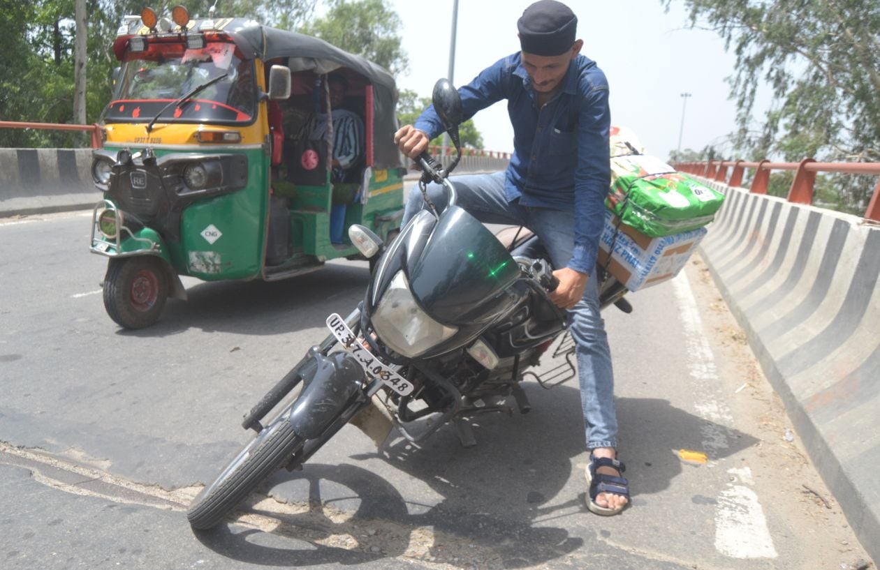 मेरठ रोड फ्लाईओवर पर बनी सड़क में हुये गड्ढे के कारण सड़क पर गिरता बाइक सवार युवक । संवाद
