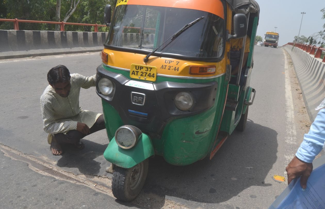 मेरठ रोड फ्लाईओवर पर बनी सड़क में हुये गड्ढे में टैम्पू का पहिया गिरने से टूटे हैंडिल को देखते चा?