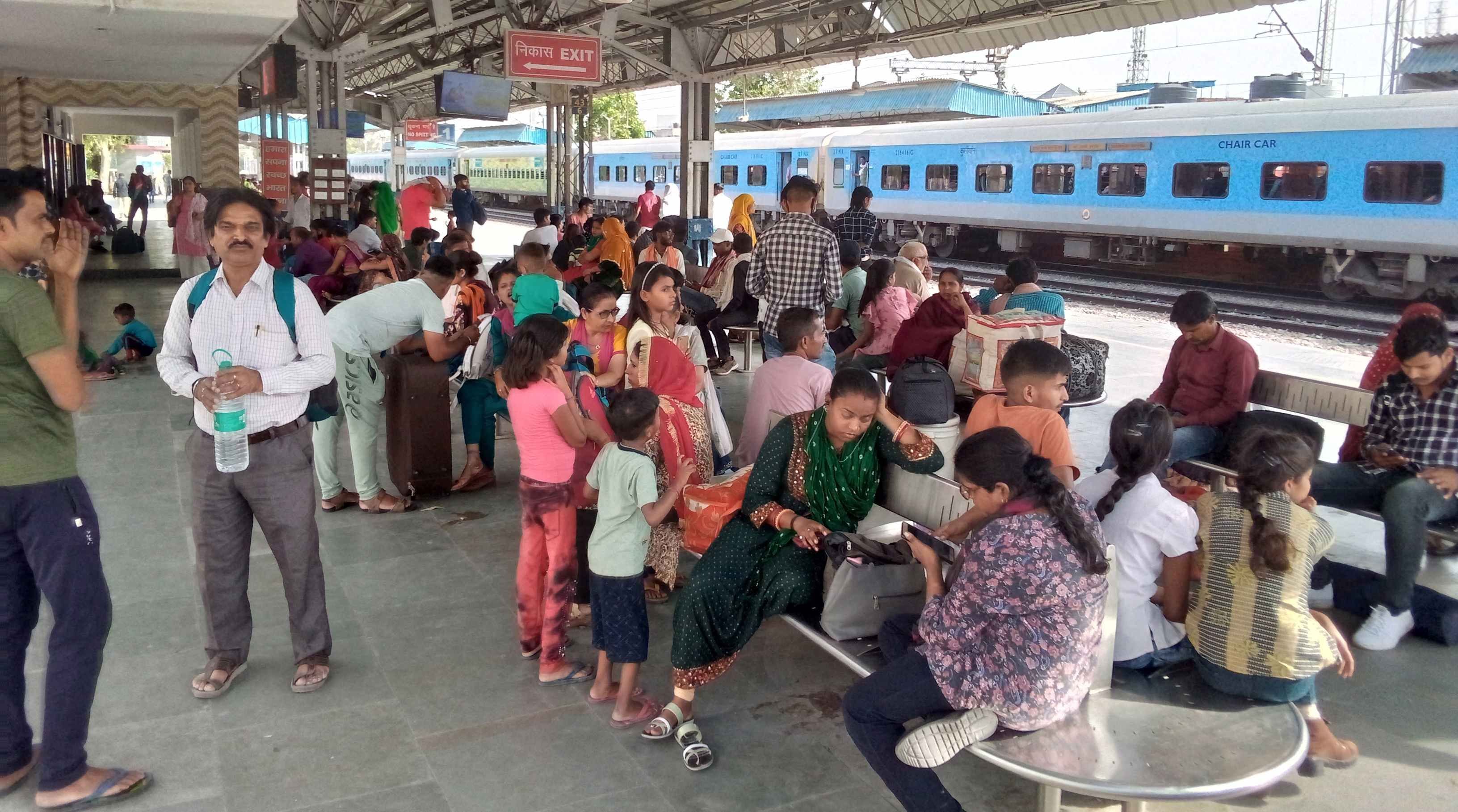  रेलवे स्टेशन पर ट्रेन आने का इंतजार करते यात्री। संवाद