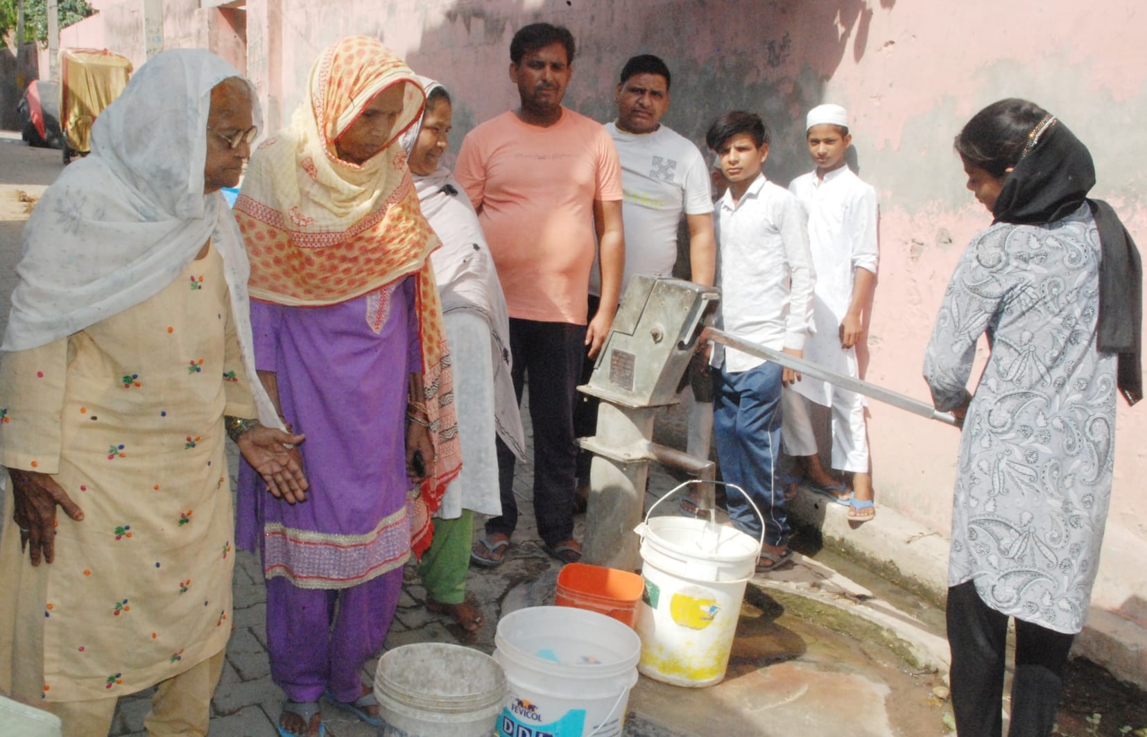 बागपत की ईदगाह कालोनी में हैडपंप से पानी भरने के लिए खड़े लोग