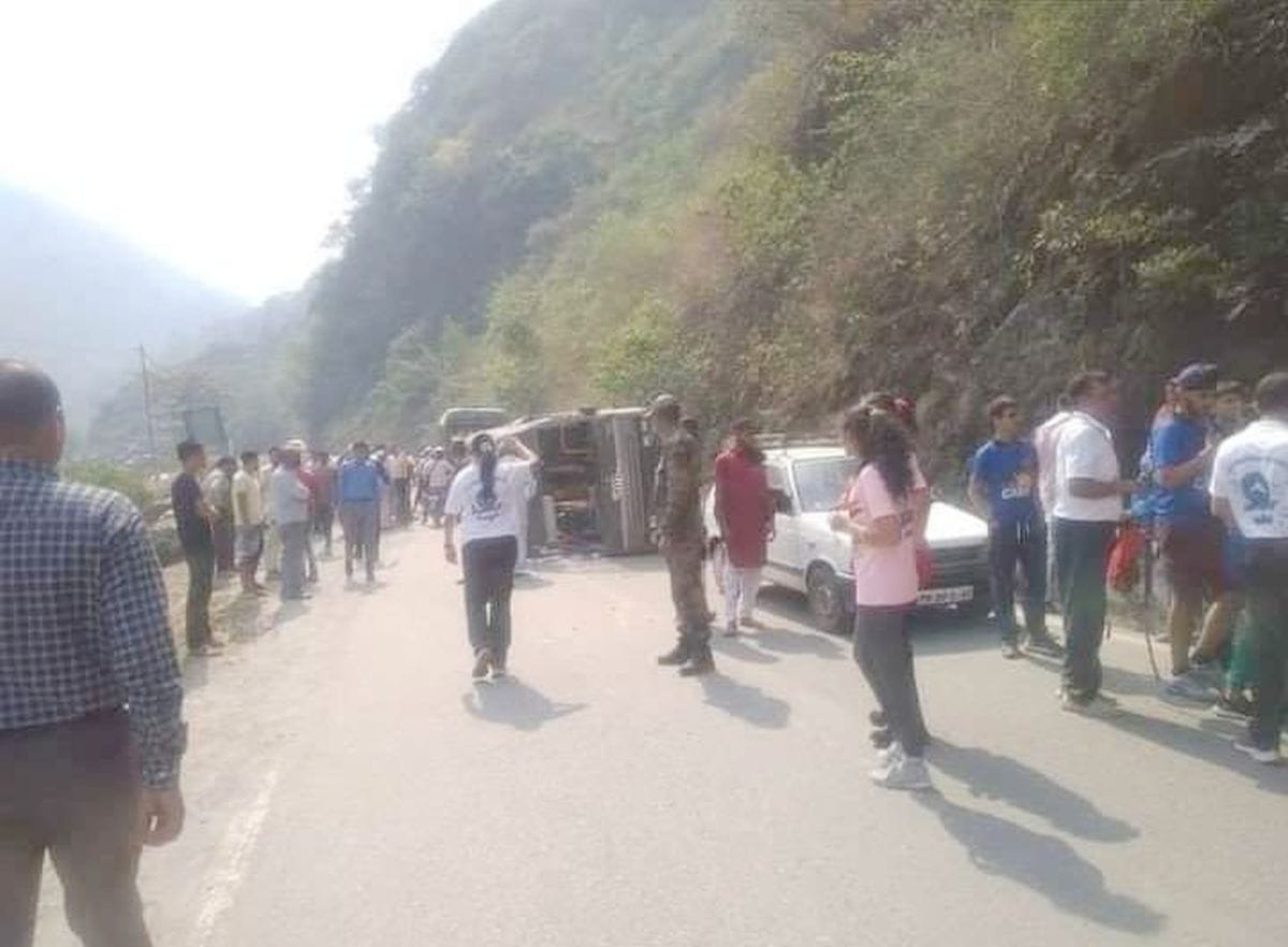 तुनूहट्टी के पास सड़क पर पलटी सेना की स्कूल वैन को देखते लोग।संवाद
