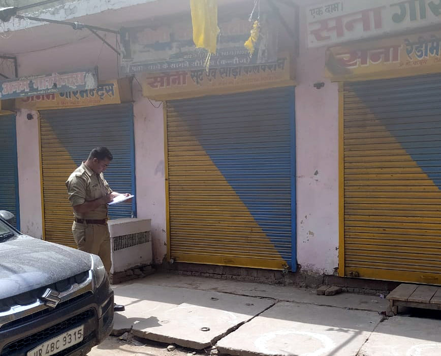 दुकानदार का नाम नोट करता पुलिस कर्मी। संवाद
