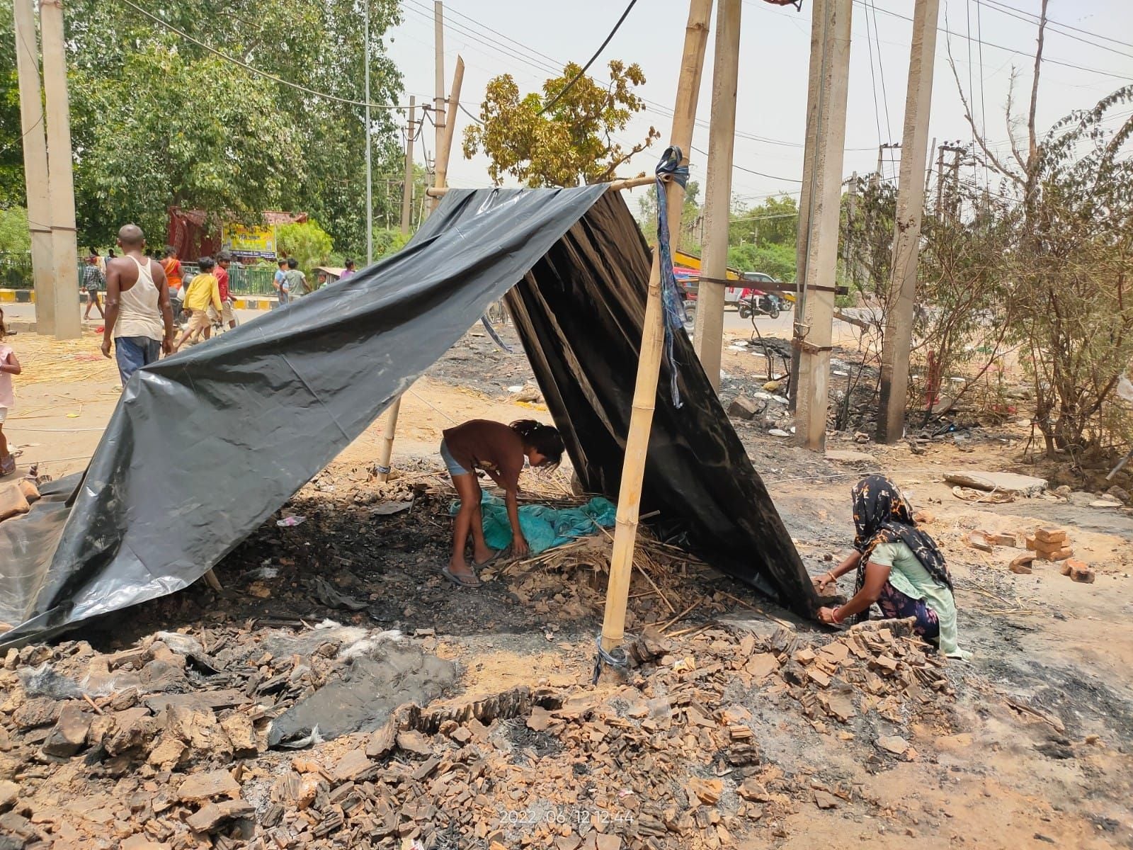 चलो दोबारा से बनाए आशियाना... झुग्गी के जलने के बाद दोबारा से झुग्गी तैयार करती महिला और उसकी बच्ची चलो दोबारा से बनाए आशियाना... झुग्गी के जलने के बाद दोबारा से झुग्गी तैयार करती महिला और उसकी बच्ची