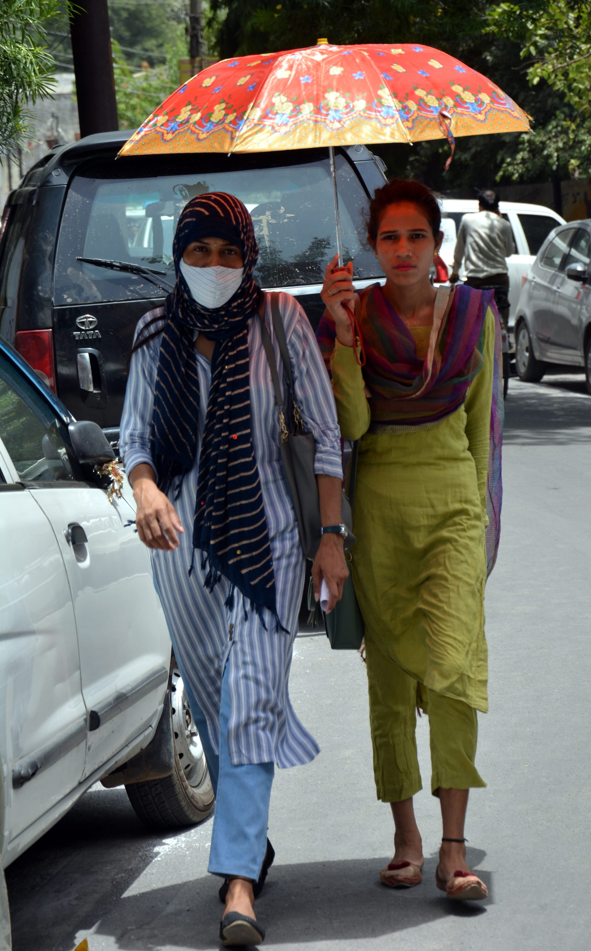 भीषण गर्मी में छाता लेकर गंतव्य को जाती युवतियां। भीषण गर्मी में छाता लेकर गंतव्य को जाती युवतियां।