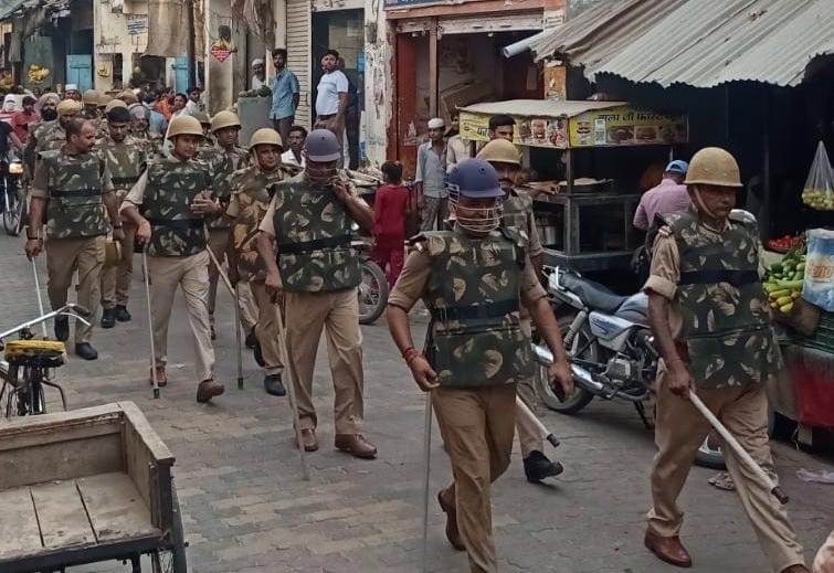 गढ़ीपुख्ता में पैदल मार्च निकालते पुलिसकर्मी। गढ़ीपुख्ता में पैदल मार्च निकालते पुलिसकर्मी।