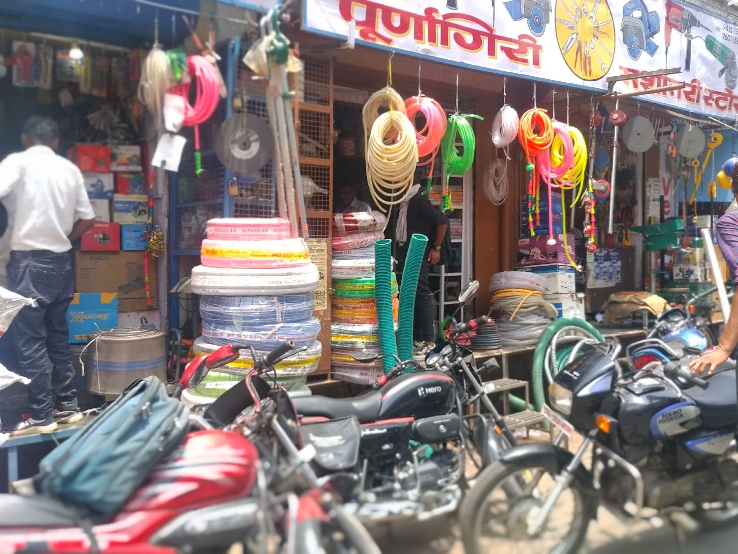 मशीनरी मार्केट में दुकान के आगे रखा सामान व खड़ी मोटरसाइकिलें मशीनरी मार्केट में दुकान के आगे रखा सामान व खड़ी मोटरसाइकिलें