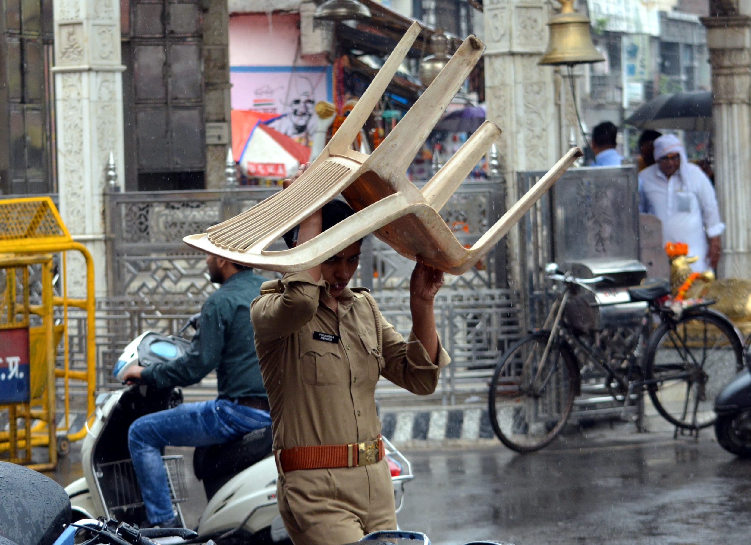 सुबह बारिश से बचने का प्रयास करती पुलिस कर्मी। सुबह बारिश से बचने का प्रयास करती पुलिस कर्मी।