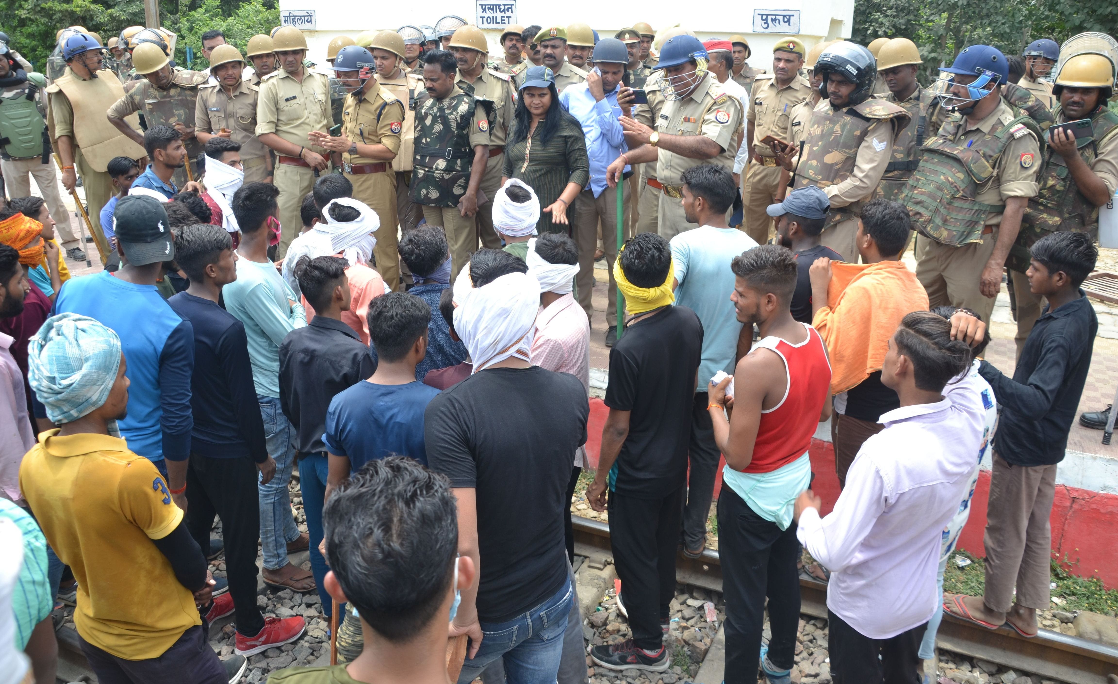 लालपुर स्टेशन पर ट्रैक जाम किए युवाओं को समझाते अधिकारी। संवाद लालपुर स्टेशन पर ट्रैक जाम किए युवाओं को समझाते अधिकारी। संवाद