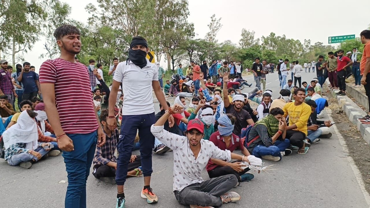 रोहतक-पानीपत हाईवे पर जाम लगाकर बैठे युवा सरकार के खिलाफ नारेबाजी करते हुए। संवाद रोहतक-पानीपत हाईवे पर जाम लगाकर बैठे युवा सरकार के खिलाफ नारेबाजी करते हुए। संवाद