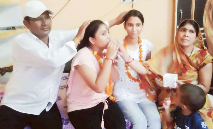 इंटरमीडिएट की जिला टॉपर कोमल का मुंह मीठा कराती मां कपूरी यादव।