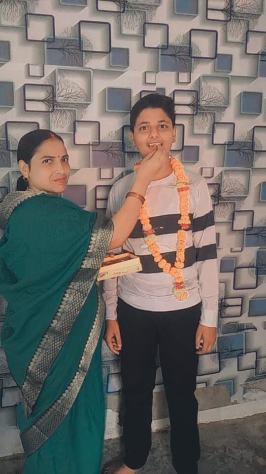 नितिन को मिठाई खिलाती मां सुधा देवी। संवाद नितिन को मिठाई खिलाती मां सुधा देवी। संवाद