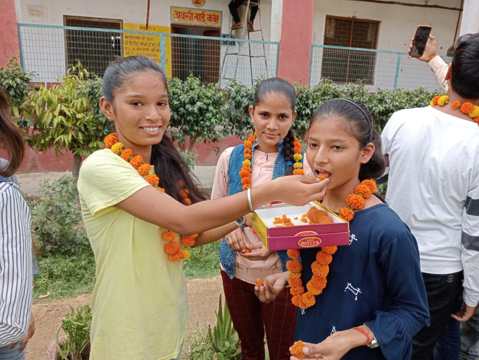  उत्तीर्ण होने पर एक दूसरे को मिठाई खिलातीं छात्राएं। संवाद