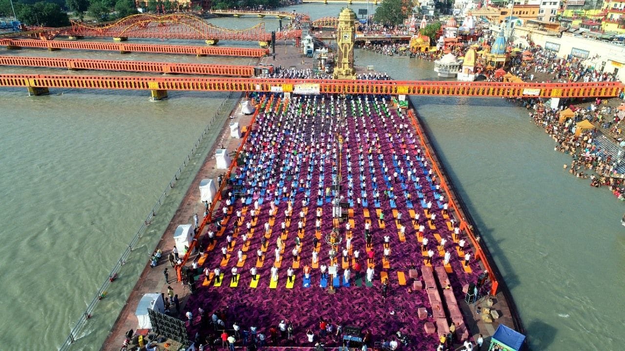 अंतरराष्ट्रीय योग दिवस पर हरकी पैड़ी पर योग करते लोग ।