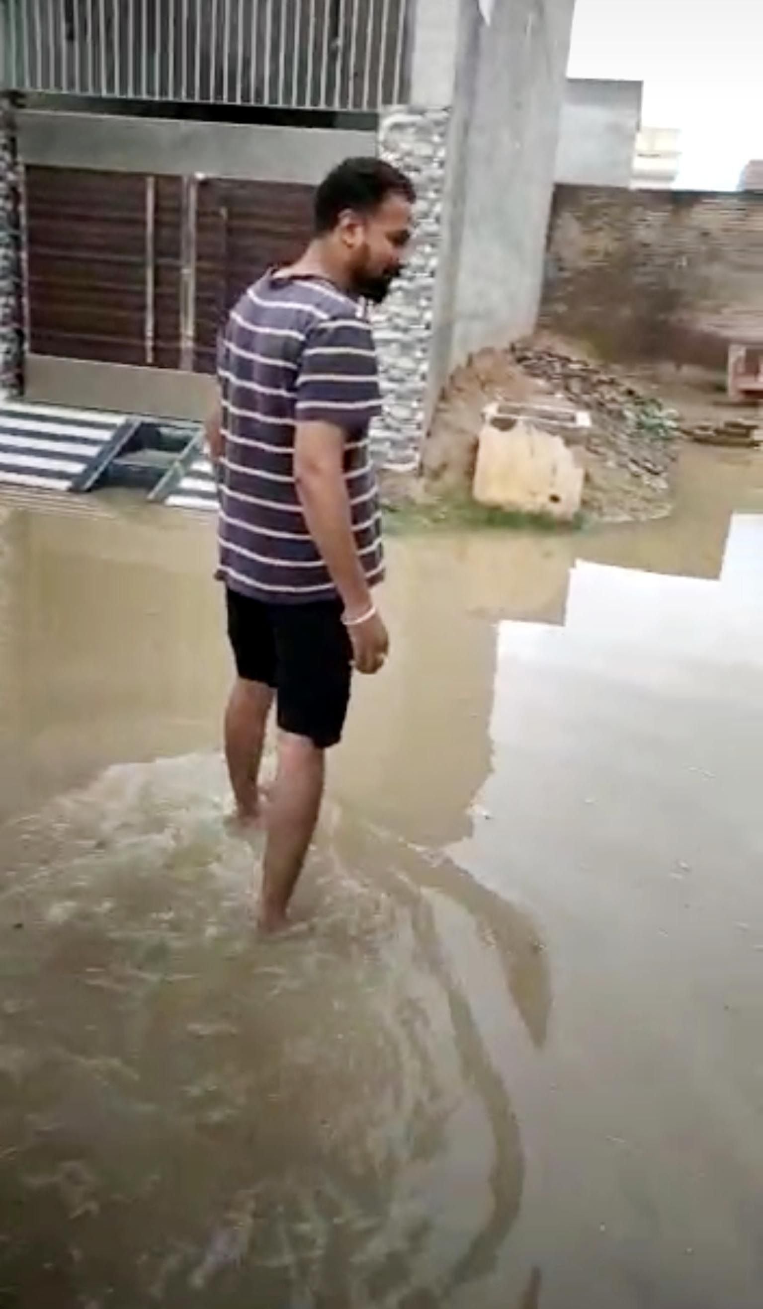 बारिश के पानी में खड़ा युवक बारिश के पानी में खड़ा युवक