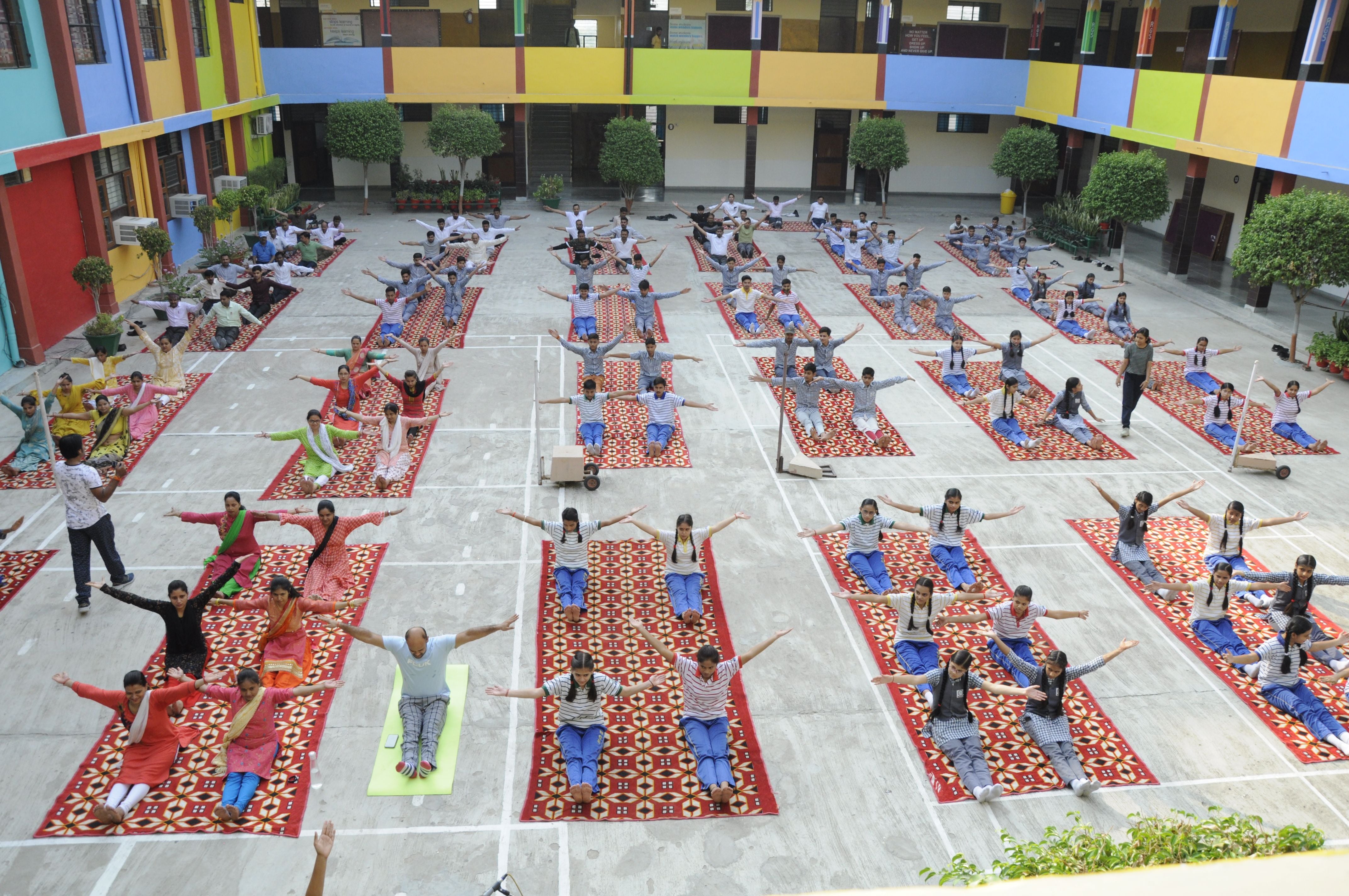  रैपिड ग्लोबल स्कूल में योगाभ्यास करते लोग। संवाद
