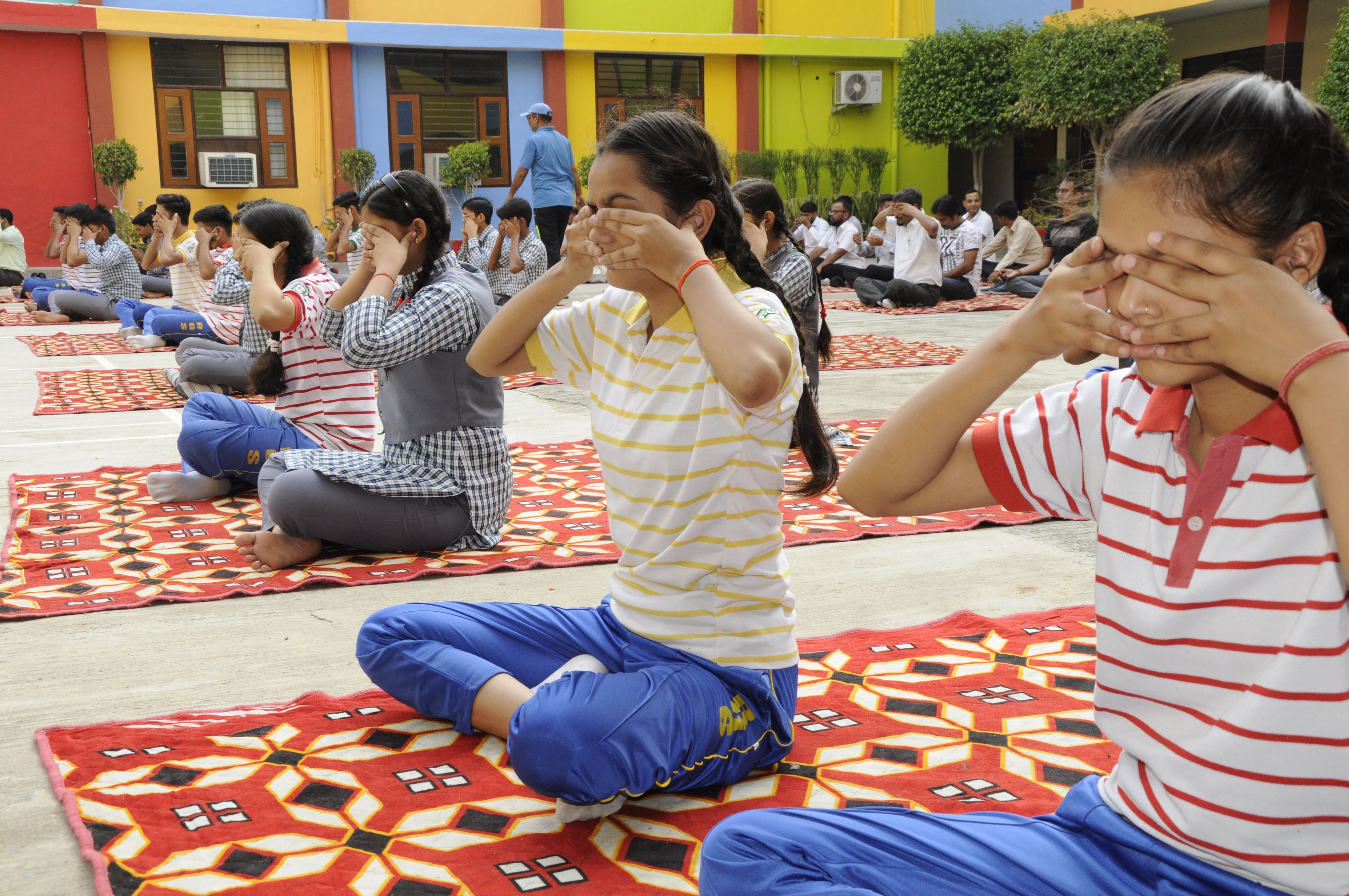  योग करते रैपिड ग्लोबल स्कूल के बच्चे। संवाद