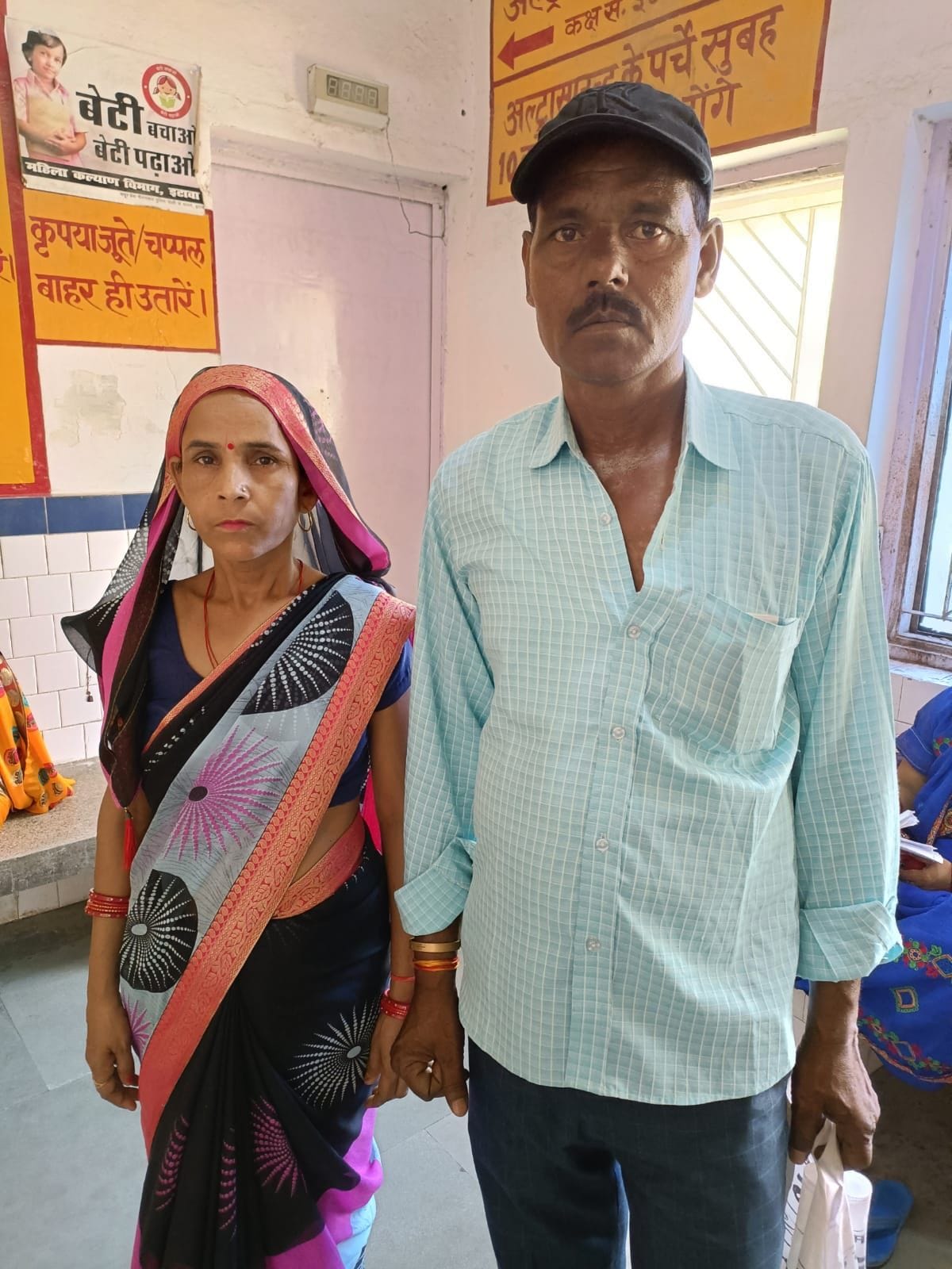 पति के साथ खड़ी राधा देवी। संवाद