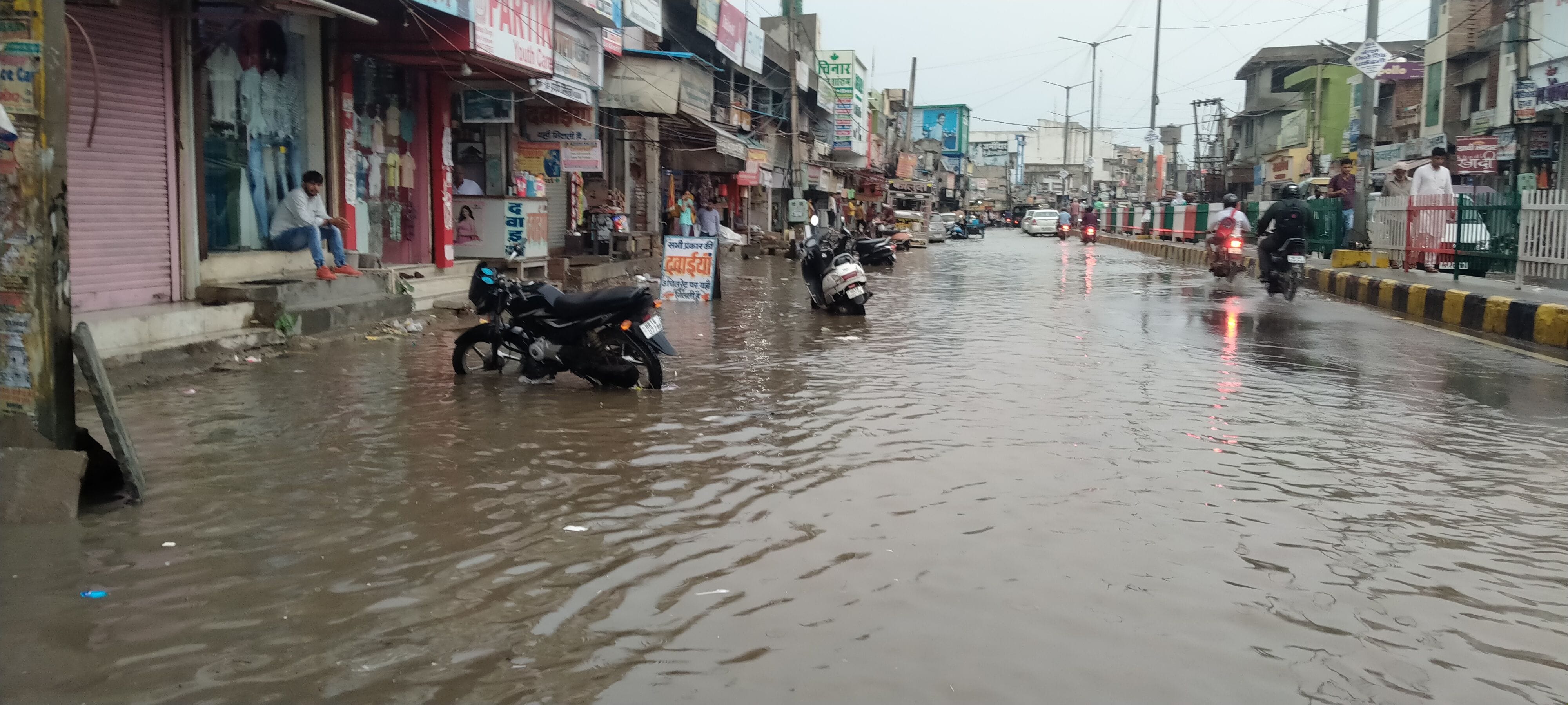 बस स्टैंड रोड पर दुकानों के सामने भरा पानी। बस स्टैंड रोड पर दुकानों के सामने भरा पानी।